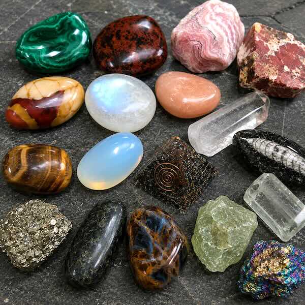 Krystaller fra M til P i Gaia Sten & Krystallers krystalleksikon med Malakit, Månesten, Pyrit, Peridot, Opalit og Orthoceras fossil.
