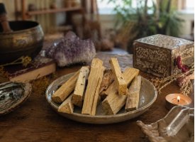 Palo santo tr� i keramiksk�l i et spirituelt rum med stearinlys og krystaller i naturligt lys