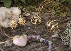 Spirituelle st�lsmykker med halsk�der, ringe og �reringe i gyldne toner omgivet af krystaller og naturlige materialer.