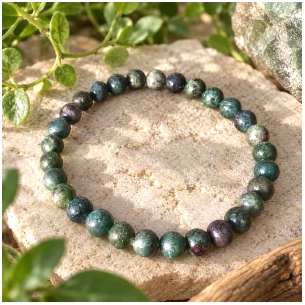 Rubin-safir-armb�nd med gr�nne planter og naturlige sten i en smuk opstilling.