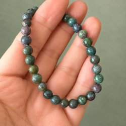 Elastisk rubin-safir-armb�nd med naturlige stenperler vist i h�nden