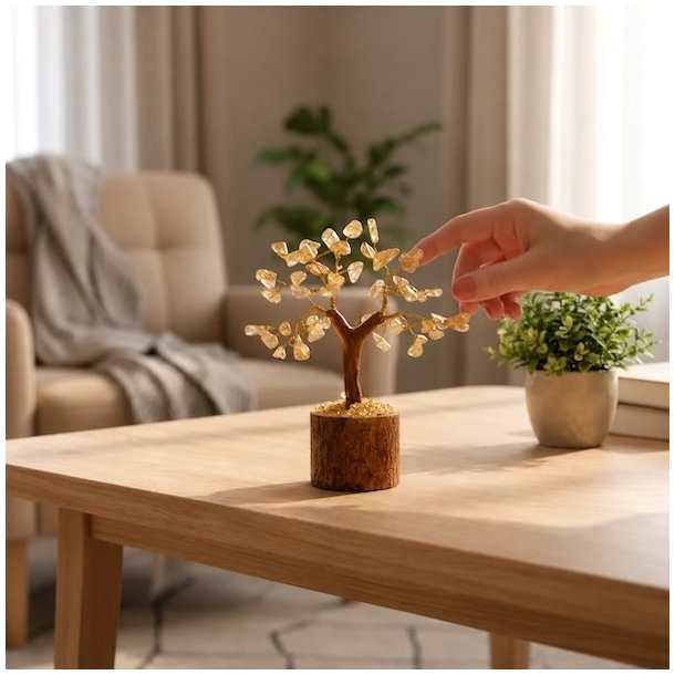 Citrin krystaltr� p� tr�base placeret p� sofabord ved siden af gr�n plante i lys og moderne stue.