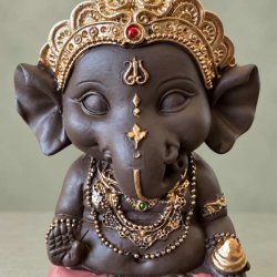 H�ndmalet Ganesha figur dekoreret med en fin r�d plet i kronen, gr�n detalje p� halsk�den og en gylden godbid i h�nden.