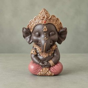 Frontbillede af m�rkebrun Ganesha elefantgud figur i siddende meditationsstilling med rosa kl�dedragt og detaljeret guldkrone.