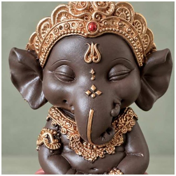 T�t p� n�rbillede af m�rkebrun Ganesha figur med fokus p� elefantgudens ansigt, snabel og detaljerede guldkrone med r�d plet.