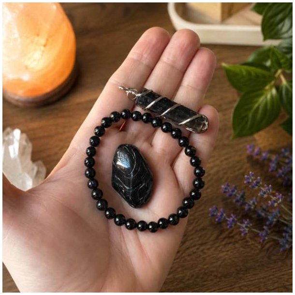 Sort turmalin armb�nd med 6 mm perler, vedh�ng i orgonit-stil og grovpoleret sort turmalin vist i h�nden.
