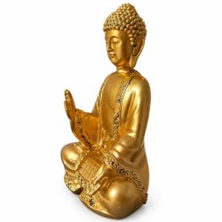 Gylden Buddha statue set fra siden med dekorative detaljer
