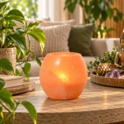 Himalaya salt fyrfadsstage med varmt lys p� sofabord i moderne Feng Shui-inspireret hjem med gr�nne planter.