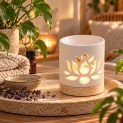 Hvid duftlampe med lotusmotiv p� dekorativ tr�bakke