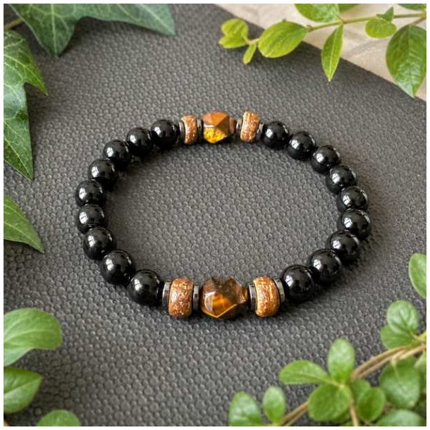 Unisex armb�nd med 10 mm sorte onyxperler, gyldent tiger�je, h�matit og tr� fotograferet i naturlige omgivelser
