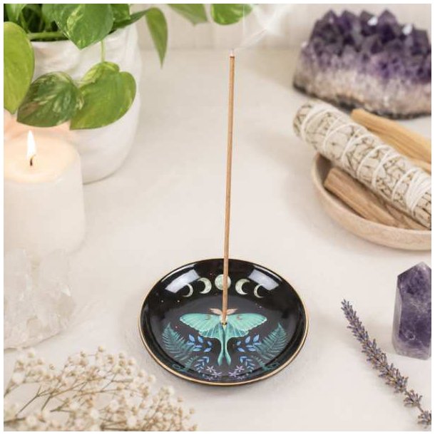 R�gelsesholder med m�nefaser og natsv�rmer i sort glaseret keramik p� lyst spirituelt alter.