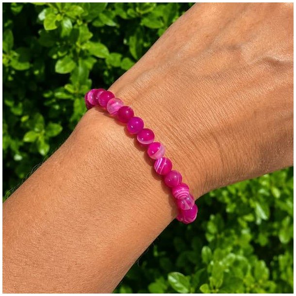 Pink agat krystalarmb�nd med 6 mm pink natursten b�ret p� h�ndled i naturligt dagslys
