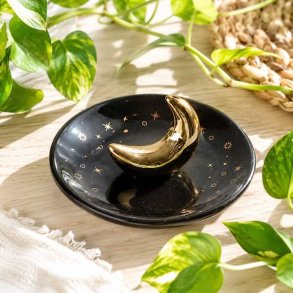 R�gelsesholder med gylden m�ne og stjerner i glaseret keramik med r�gelsespinde p� tr�bord i hyggelige omgivelser.