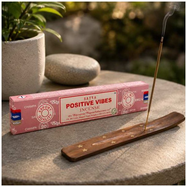 Satya Positive Vibes h�ndrullede r�gelsespinde 15 g ved en r�gelsesholder med t�ndt r�gelsespind p� stenbord.