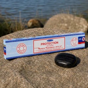 Satya Protection h�ndrullede r�gelsespinde 15 g p� natursten ved siden af en sort sten.