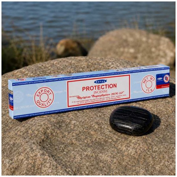 Satya Protection h�ndrullede r�gelsespinde 15 g p� natursten ved siden af en sort sten.