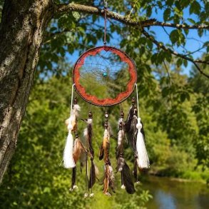 Unik h�ndlavet shaman dr�mmefanger med fjer, kvaster og turkis sten h�ngende i et tr� i natursk�nne omgivelser.