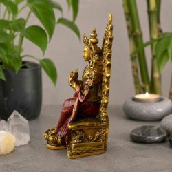 Maitreya Buddha figur i guld og bordeaux set fra siden med udsmykket trone.