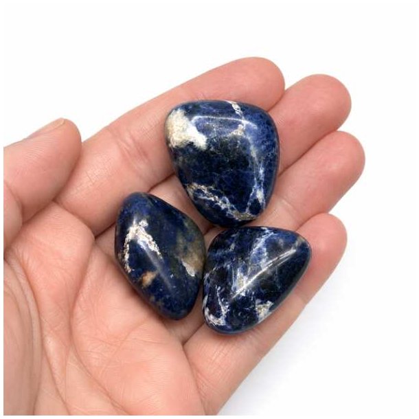 Sodalit tromlesten 2,5-3 cm vist i h�nd for at illustrere st�rrelse og kvalitet