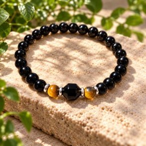 Krystalarmb�nd med 6 mm perler af sort onyx og tiger�je fotograferet indend�rs i fotostudio p� en r� sandsten.