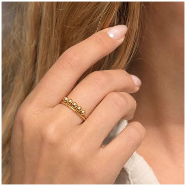 Guldfarvet stressring med flytbare kugler p� h�nd