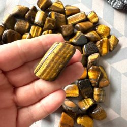 N�rbillede af poleret tiger�je lommesten med gyldne striber